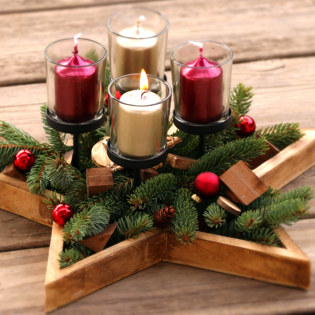 Advent candles sitting in a star with greenery