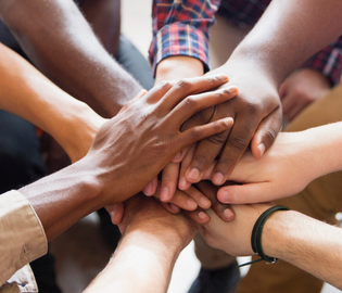 group of hands gather together in a circle